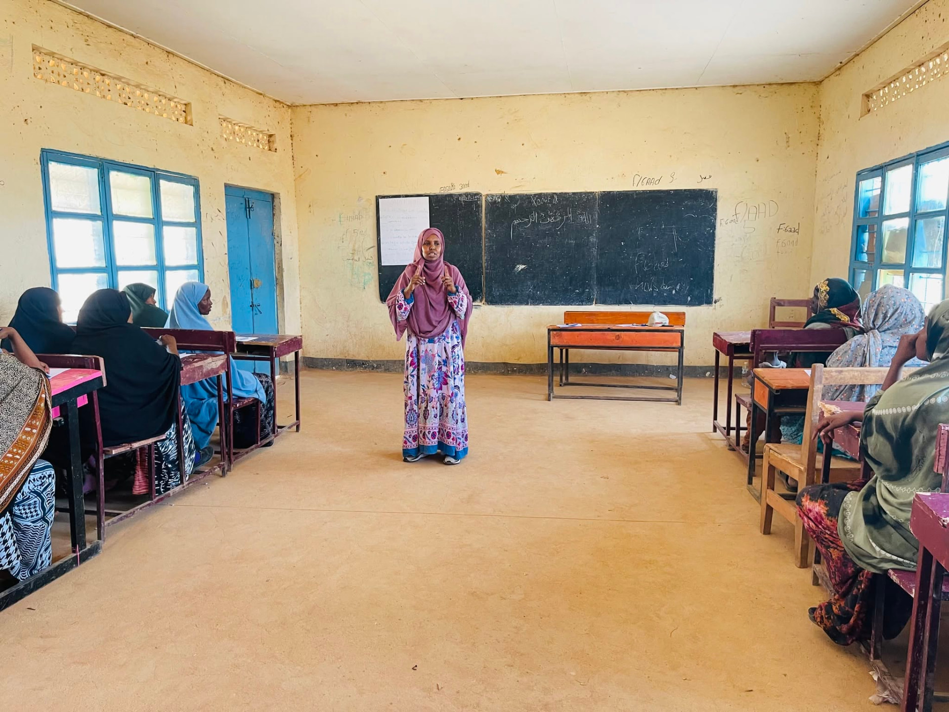Women seated at classroom desks during a peer-to-peer public speaking workshop
