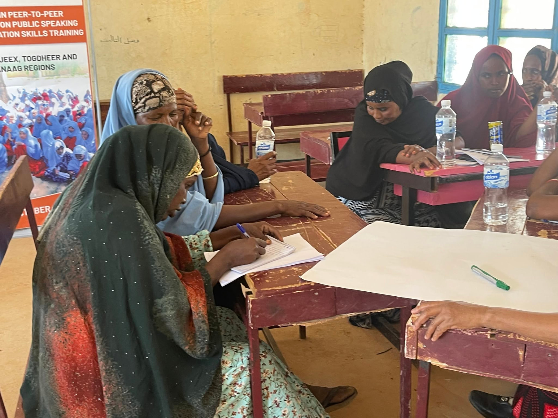 Women taking notes during a peer-to-peer negotiation skills dialogue circle