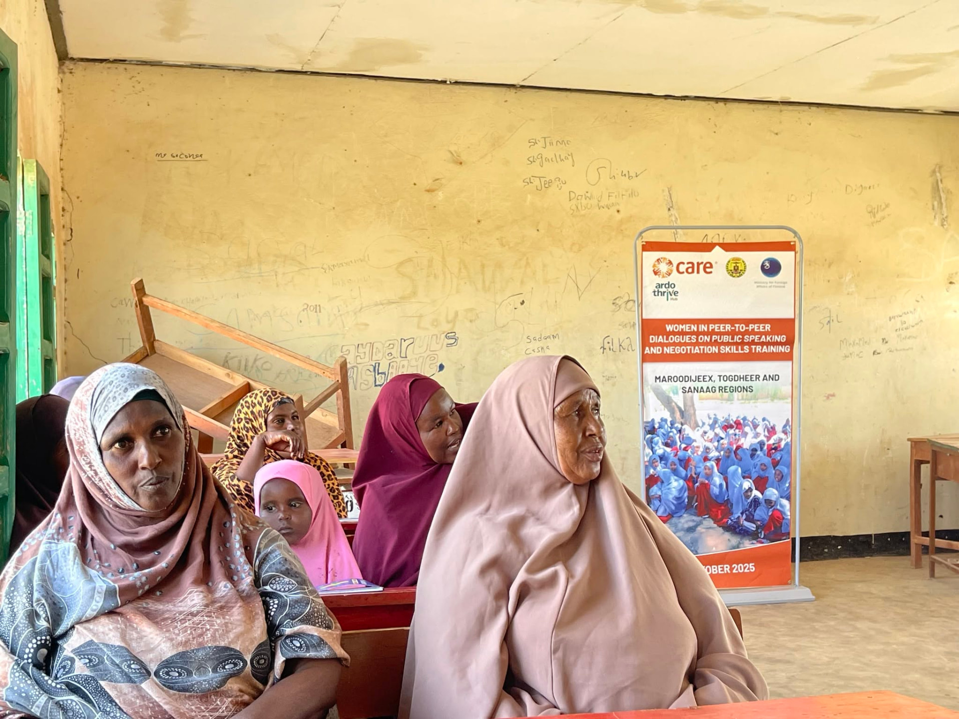 Participants seated beside the CARE and Ardo Thrive Hub project banner